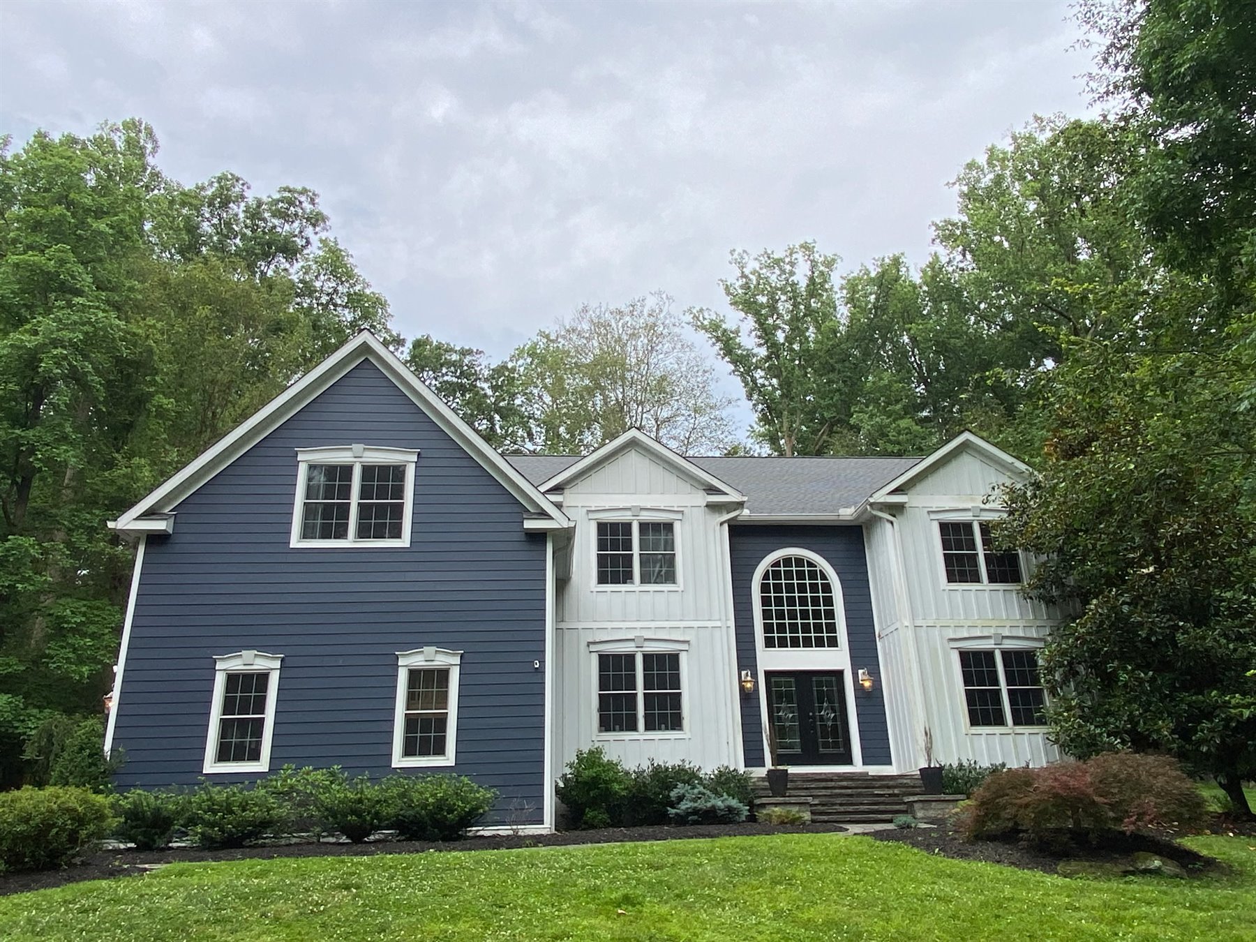 Residential home with blue siding and a detailed roofline